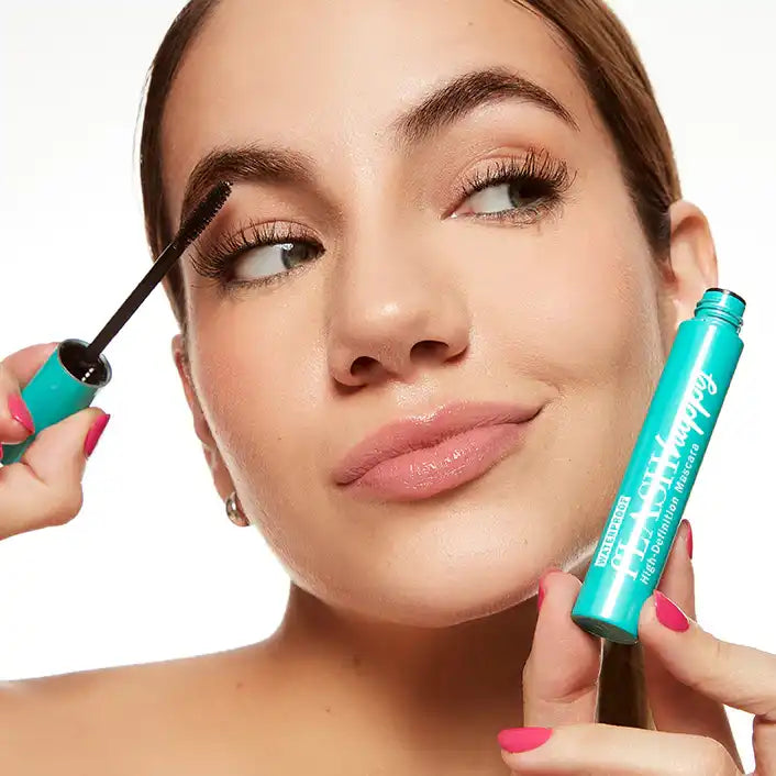 Woman applying fLASH Cosmetics mascara, showing long, full lashes and product packaging
