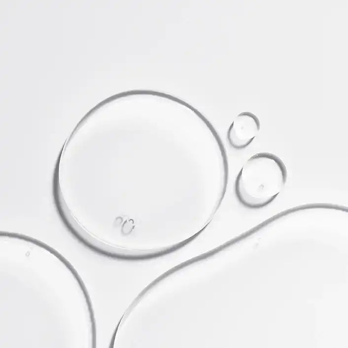 Clear serum drops on white background, fLASH Cosmetics eyelash serum texture